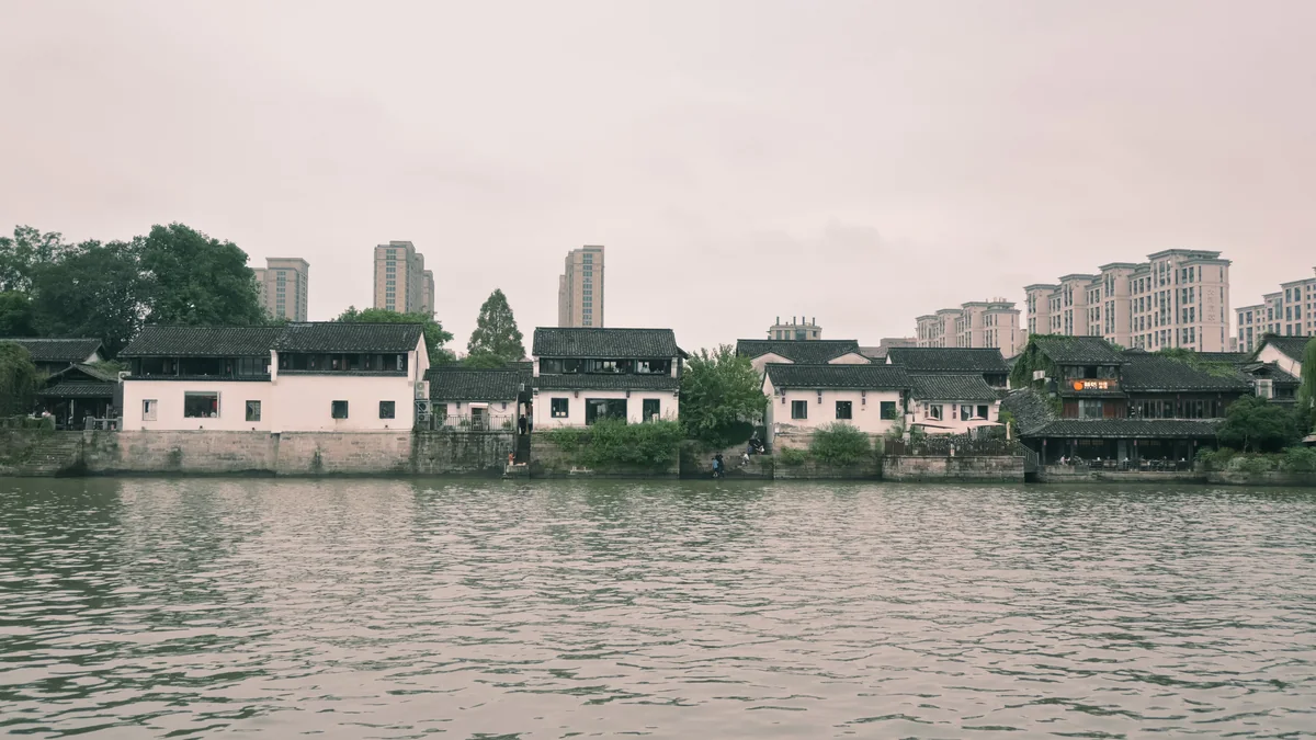水岸白墙民居与后方城市楼房