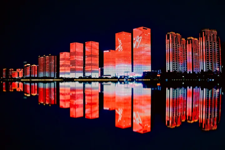 红色灯光建筑在夜间水面上的倒影