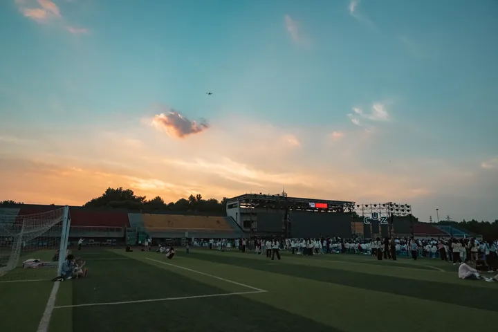 球场上空的橙色落日云与蓝色天空