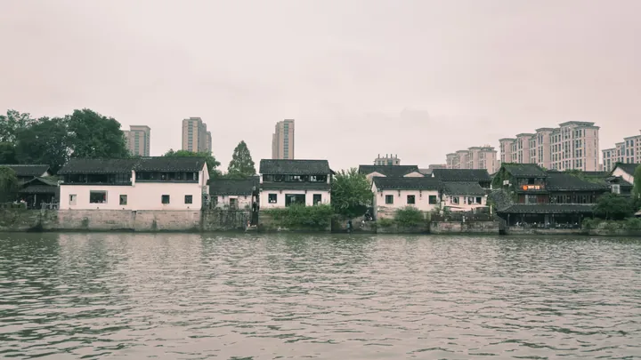 水岸白墙民居与后方城市楼房