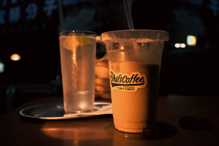 灯光下的咖啡与水杯。