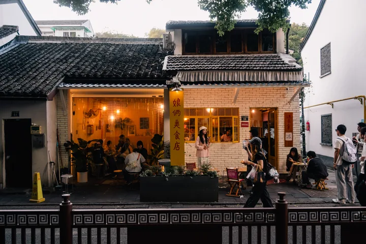 白墙店铺透出的暖黄色灯光。